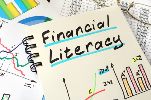 "Financial Literacy" written in sketchbook or notebook, drawn graphs, laying on graphs and charts