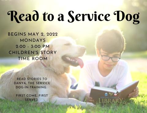 Photo of dog enjoying a book with a young reader